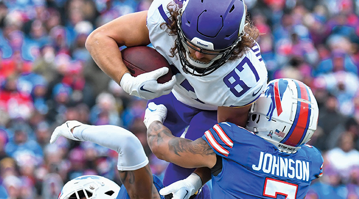 Photo of one pro football player tackling player with the ball