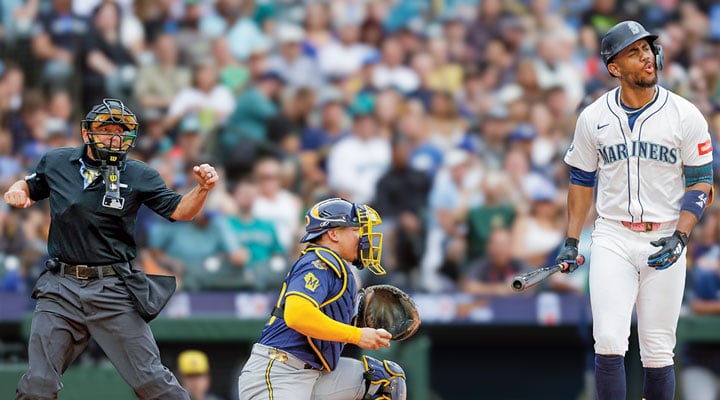 A Mariners batter reacts after a strikeout as a catcher catches the pitch and an umpire signals the call